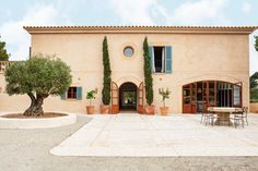 an outside view of a house with potted trees