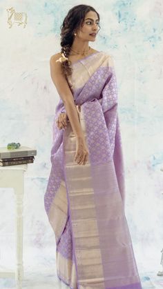 This exquisite lavender Kanchipuram silk saree, subtly features thilagam buttas across its body. The border is adorned with delicate zari detailing and kattu mayil buttas, while the pallu is beautifully enhanced with diamond zari work. Lavender Silk Saree, Lavender Saree, Fashionable Saree, Lavender Silk, Bridesmaid Saree, Bridal Lehenga Collection, Fashionable Saree Blouse Designs