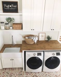 a washer and dryer in a laundry room next to cabinets with white doors