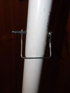 a close up of a white pole with a metal holder on it's end