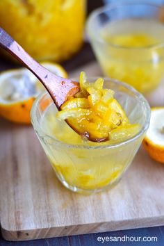 a spoon full of orange jello on top of a cutting board next to sliced lemons