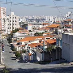 an empty street in the middle of a city with buildings and power lines above it