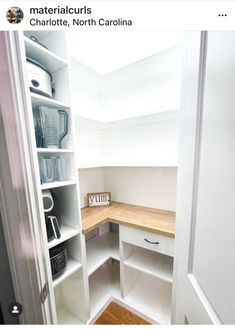 an empty pantry with white shelves and wooden counter tops