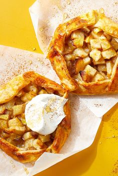 two apple pies sitting on top of parchment paper next to each other with an egg in the middle