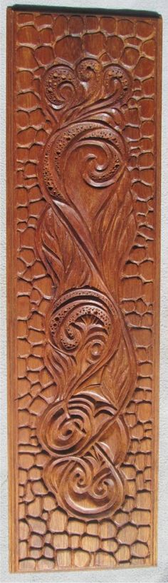 an intricately carved wooden panel with swirls and leaves