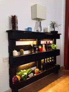 a shelf filled with lots of bottles next to a wall