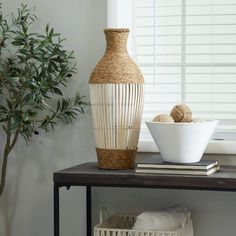 a white vase sitting on top of a table next to a bowl and other items