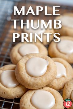 some cookies with white frosting are on a cooling rack and the words maple thumb prints