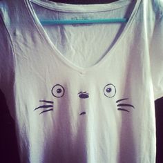 a white t - shirt with an angry cat drawn on it's chest and eyes