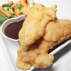 fried fish and vegetables on a plate with dipping sauce