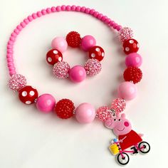 Includes Necklace and Bracelet  Necklace and bracelet are made with Stretch Magic Elastic. No need for clasps! Peppa Pig Pendant made of PVC Pink and red 20mm chunky beads  Please message me if you would like it made longer or shorter. I can add or remove a bead. Perfect for a photo prop or dress up! 👗  Recommend Ages: 3 and up Please supervise children with small parts Playful Round Beads Jewelry For Valentine's Day, Playful Valentine's Day Jewelry With Round Beads, Playful Personalized Red Jewelry, Plastic Bead Jewelry For Birthday, Plastic Round Beads Jewelry For Birthday, Pink Plastic Birthday Jewelry, Pink Plastic Jewelry For Birthday, Playful Red Jewelry For Birthday, Adjustable Red Necklace For Birthday