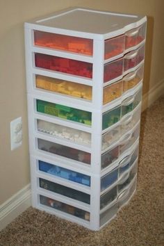 a stack of plastic drawers in the corner of a room with carpet on the floor