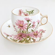 a cup and saucer with pink flowers painted on it