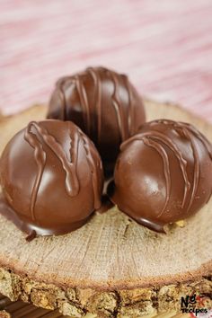 three pieces of chocolate sitting on top of a piece of wood