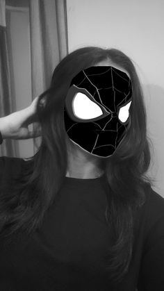 a woman wearing a spiderman mask and holding her hair in front of her face