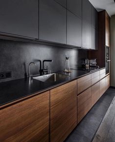 an image of a kitchen with black countertops and wooden cabinets in it, which is also featured on instagram