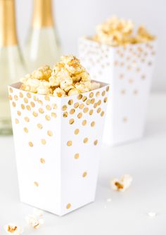 two white boxes filled with popcorn sitting on top of a table