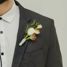 a man in a suit with a boutonniere on his lapel flower