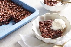 two bowls filled with brownies and ice cream sitting on top of a white table