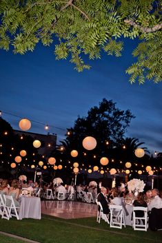 an outdoor wedding reception with paper lanterns