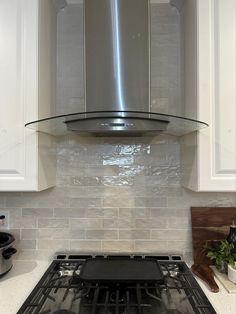 a stove top oven sitting inside of a kitchen next to white cabinets and counter tops