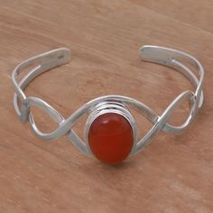 A helix of sterling silver flanks a stone of orange-red carnelian featuring a minimalist and elegant design reminiscent of DNA strands. This cuff bracelet is crafted by Balinese artisan Komang Suastra who has been involved in jewelry from a young age. Simple Cuff Bracelet, Carnelian Bracelet, Silver Signet Ring, Silver Gemstone Jewelry, Silver Chain Bracelet, Sterling Silver Cuff Bracelet, Minimalist Bracelet, Sterling Silver Bangles, Sterling Silver Cuff