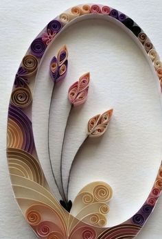 two paper flowers made to look like they are in the shape of a circle with swirls