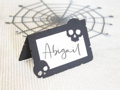 there is a black and white tag with the word angigam on it next to a spider web