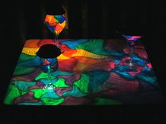 a table that has some colorful lights on top of it and a vase in the middle