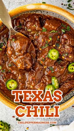 A big plate of Texas Chili topped with peppers and with a metal spoon on top. Chili Beef, Chili Bean