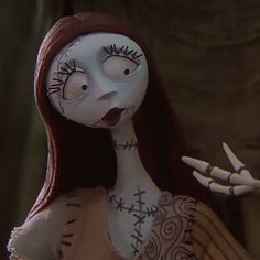 a cartoon character with long red hair and white makeup holding a knife in her hand