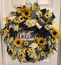 a welcome wreath with sunflowers and plaid ribbon hanging on the front door,