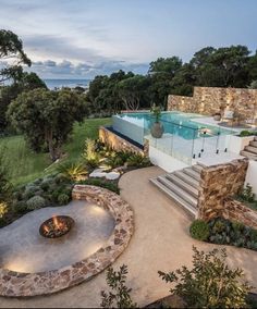 an aerial view of a house with a swimming pool and fire pit in the foreground