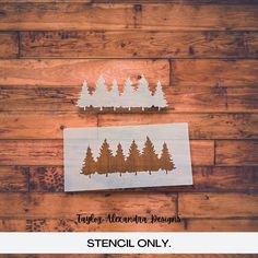 two stencils on wood with pine trees