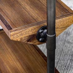 a close up of a wooden table with an iron pipe on the bottom and wood top