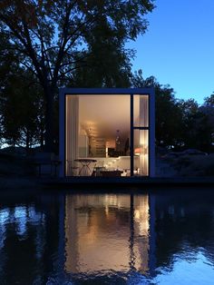 an image of a house on the water with trees and sky in the back ground