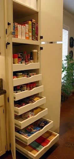 an open pantry door in a kitchen with lots of food on the shelves and drawers