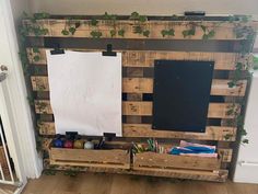 a wooden pallet with two chalkboards and some paint