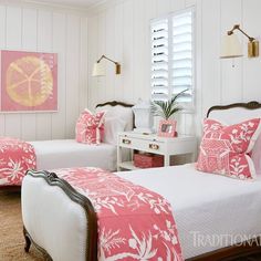 two beds in a room with pink and white decor on the walls, along with windows