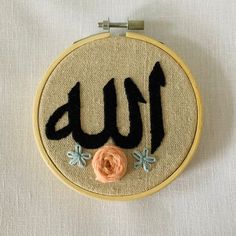 an embroidered wall hanging with the word love written in black and orange letters on it