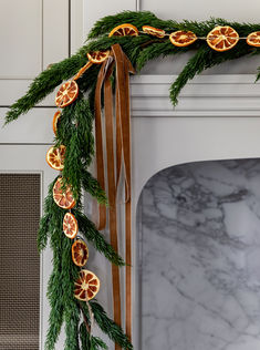 an orange slice garland on a fireplace mantel