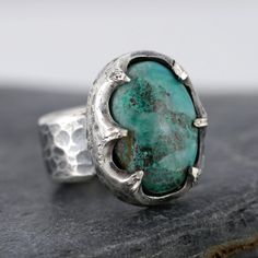 .999 Fine silver ring with a Chrysocolla gemstone. US Ring Size 8 Chrysoprase gemstone measures 2.1cm by 1.5cm Ring band width: 1.1cm Handmade by Mike Summers. We are husband and wife Mike and Annie, making silver jewelry in two uniquely different styles. With a passion for rocks and gemstones, we also cut and polish our own cabochons to use in our creations. We live and work in a tiny cabin in a remote part of Talkeetna in Alaska and it's always a bit of an adventure crossing our creek in a boat to get on the roads to the post office. We have set our dispatch time to 1-2 weeks, and we usually make a visit to the post office once a week all being well. We do not want anyone buying from us to be disappointed if you need a quick delivery, so please feel free to contact us before ordering and Gift Ring With Large Chrysoprase Stone, Silver Emerald Oval Cabochon Ring, Sterling Silver Patina Ring, Sterling Silver Rings With Large Green Stone, Silver Chrysoprase Round Rings, Sterling Silver Ring With Large Green Stone, Gift Turquoise Sterling Silver Ring With Patina, Sterling Silver Emerald Ring With Large Stone, Silver Emerald Cabochon Ring In Sterling Silver