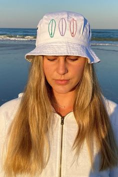 I am in love with this surfboard design on this adorable white bucket hat. It screams summer, ocean, and Hawaii. I will be wearing this beach bucket hat to the beach everyday. #beachthemedbuckethat #surfbuckethat #beachbuckethatoutfits