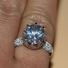 a woman's hand with a diamond ring on top of her finger and an engagement band