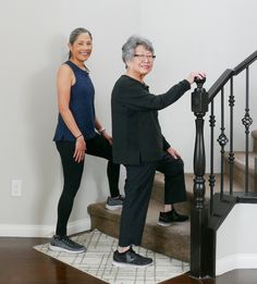 two women are standing on the stairs and smiling