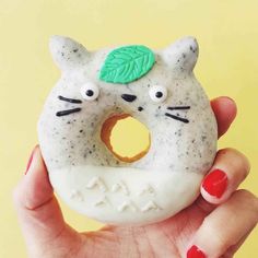 someone is holding up a fake donut that looks like a cat