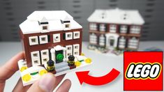 a hand holding up a lego house with the front door open and side windows closed