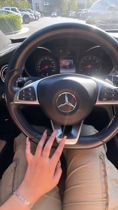 the woman is driving her car with both hands on the steering wheel and holding onto the dashboard