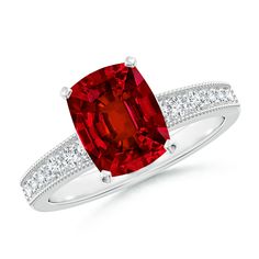 a ring with a red stone and diamonds on the sides, set in white gold