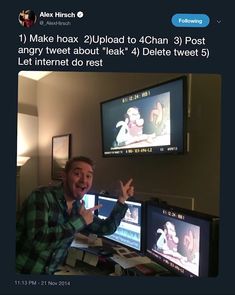 a man standing in front of two monitors pointing at the same person's hand